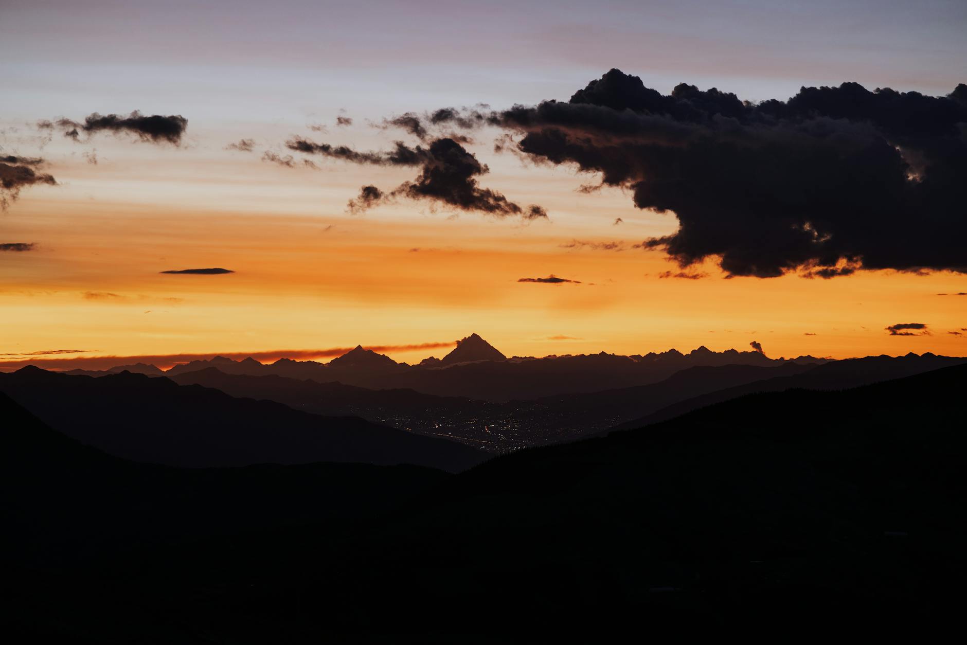 A breathtaking sunset over Cusco mountains with dramatic clouds and vibrant colors.