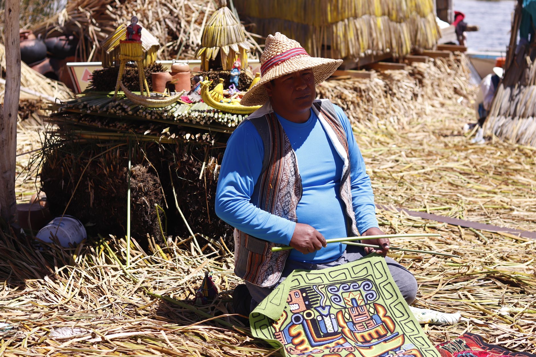 A local artisan crafting traditional art on Uros Floating Islands, Lake Titicaca, Peru.