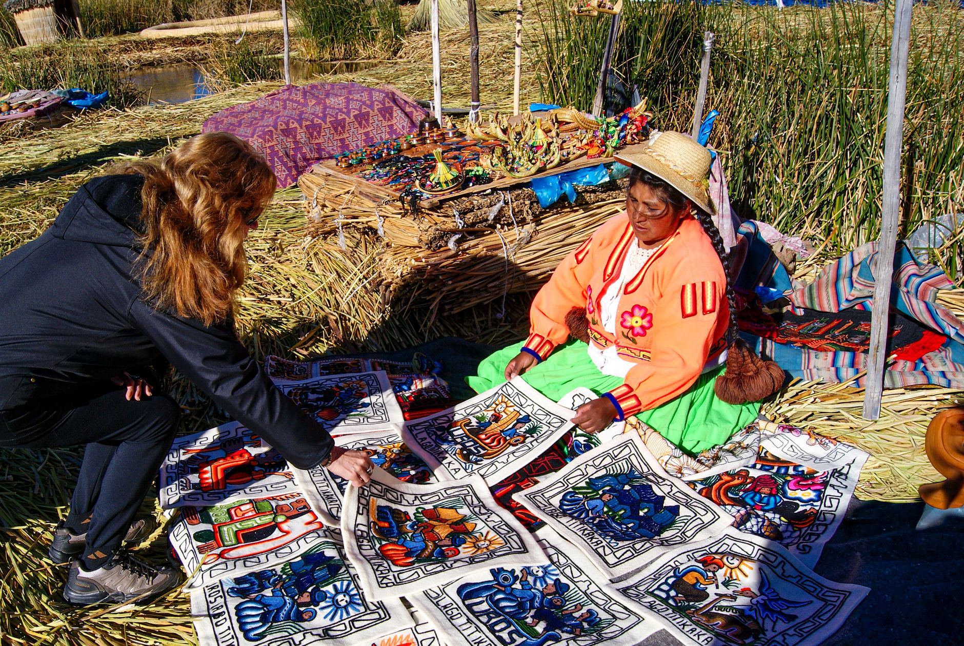 A woman selling traditional textiles at a vibrant outdoor market in Puno, Peru.